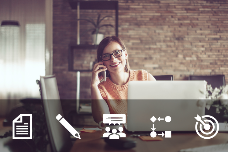 A woman talking to her phone while on her computer